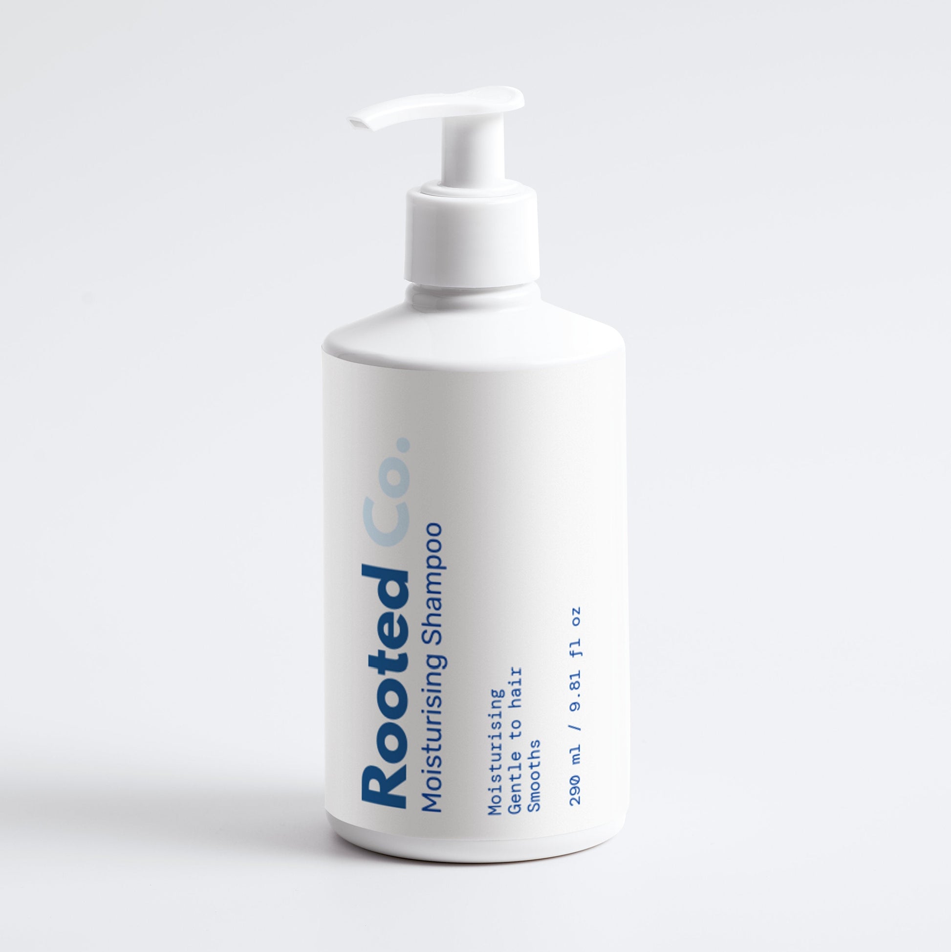 White bottle of Rooted Co. moisturizing shampoo on a light gray background