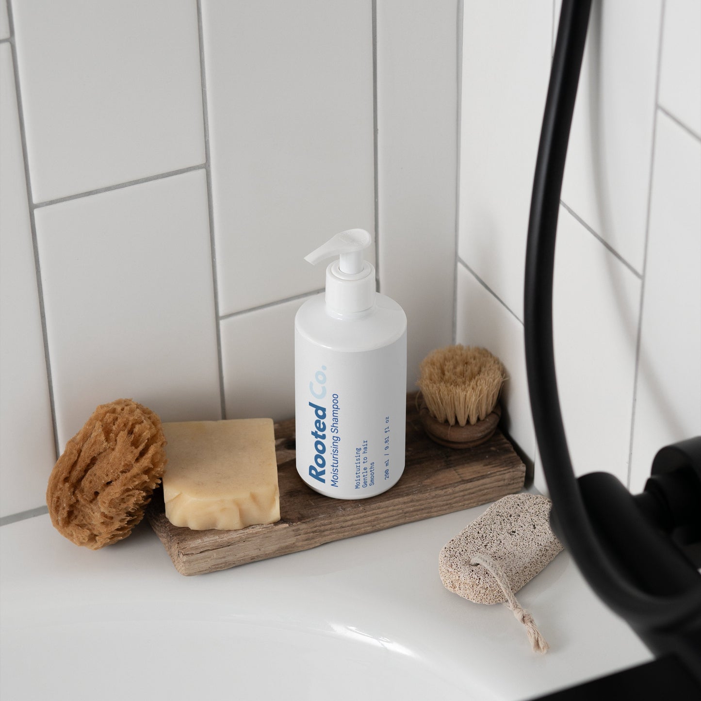 Bathroom counter with 'SAMI beauty' product, sponges, and soap on a wooden tray.