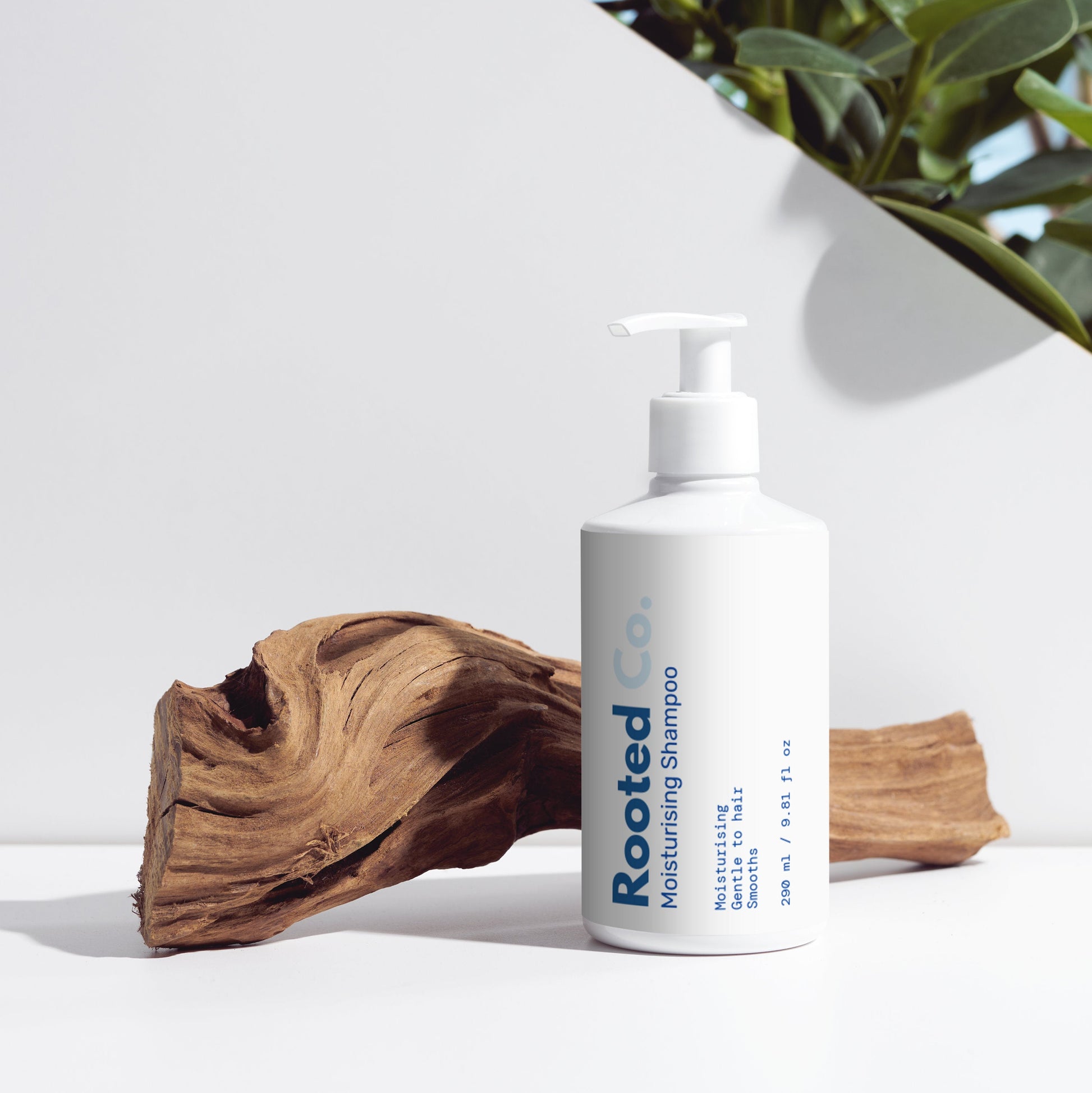 Aurevia bottle of sensitive skin facial and body cleanser on a white surface with a plant in the background.